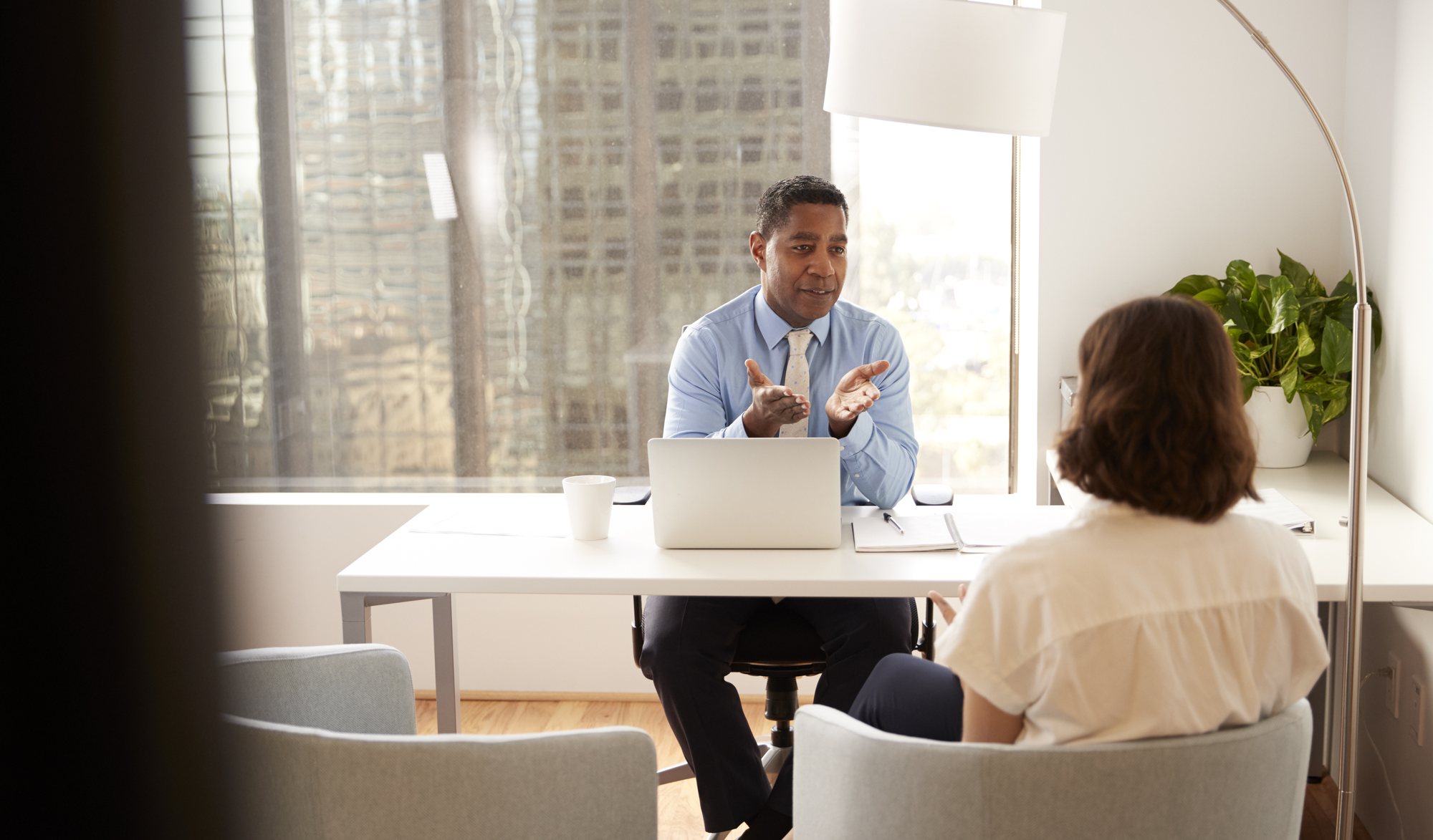 A tax practitioner going through a client&rsquo;s return with them across a desk